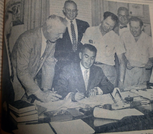 Signing of the contracts for the construction of the new Jewish Community center Building was a festive occasion in Milton Fredman's office as President William B. Schwartz signs the construction contract with C.A. Larsen Construction Company as Chris Larsen looks on.  At the signig were: Albert A. Hutler, Executive Director of the Jewish Community Center; Larsen; Fredman, who drew the contract; President Schwartz; Sidney Rose, Chairman of the Building Committee; John Ruskin and Maury Novak, Building Committee members.  Rodin Horrow, a Building Committee member, was absent.