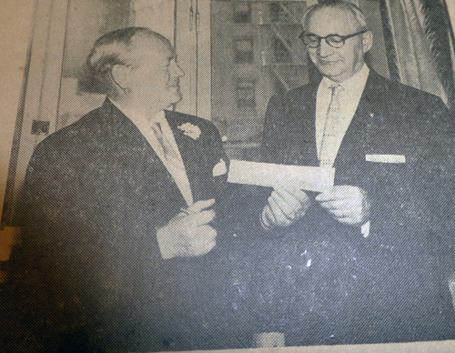 William Colt, Treasurer of the United Jewish Fund, after signing a check for the United Jewish Appeal Emergency Cash Rescue Fund, hands it to Abraham Sklar, Chairman of the Campaigner's Division of the 1957 campaign, to take with him for presentation in New York City to the United Jewish Appeal at the Emergency Conference, where he and Mrs. Sklar will represent the Jewish community of San Diego. San Diego's share of the $50,000,000 Cash Drive, which ended on June 9, was $75,000.