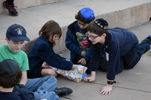 Pupils anxiously unwrap a package to find the next set of Tu B'Shevat instructions